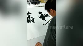 Armless man in China uses his feet and mouth to paint stunning artwork
