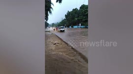 Drivers battle through flooded road after heavy rain in the Philippines