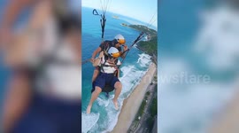 A thrill-seeking tourist has been filmed being SICK - while paragliding!