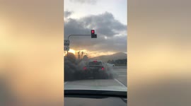 Pickup truck belches out thick black smoke while waiting at traffic lights