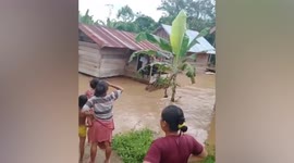 Locals watch on as house is swept away by raging floods in Indonesia