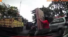 Motorcycle passenger drops 40-inch television while trying to navigate traffic