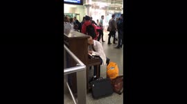 An unknown man plays the piano at the St Pancras railway station in London