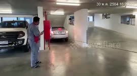 Bungling driver gets stuck in narrow car park lane