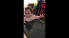 Cute baby girl tries to feed herself and messes up everything