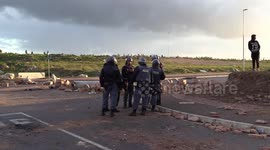South African police and land invaders clash in seaside town