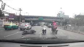 Motorcycle rider crashes to ground after snagging ropes hanging from truck in Thailand