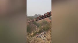 Wooden cable bridge sways dangerously as hundreds of tourists walk across in Nepal