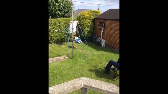 Grandad pulls Granddaughter in swing by a rope as he sits in chair! 