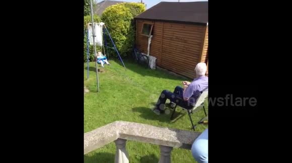 Granddad pulls Granddaughter on swing from the comfort of his chair
