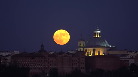 Photographer captures strawberry supermoon appearing over the Madrid skyline