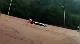 Chinese police officer smashes window to rescue woman trapped in car submerged by floodwater