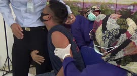 Hilarity as Indonesian prisoner scared of injections clings to guard during vaccination