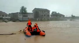 Firefighters use lifeboats to evacuate residents trapped in flooded buildings in southern China