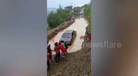 Kind locals help motorists cross mountain road submerged in muddy water after thunderstorm in the Philippines