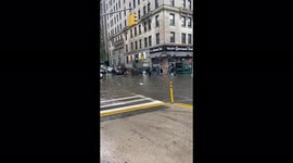 Two men unclog a sewage drain during the New York flood from Storm Elsa