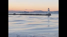 Gentle Hypnotic Waves During Sunset with Light and Mountains in Background