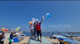 Palestinian fishermen launch balloons with images honoring the victims of the Israeli airstrike