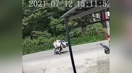 Riders flung from scooter as it's caught by loose cable hanging over road in China