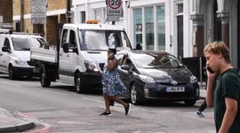 London woman carries huge water bottle on her head during UK heatwave