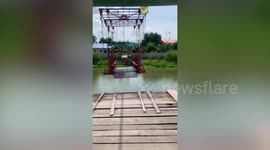 Rider and his motorcycle crosses canal by riding cable car