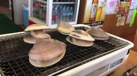 Watch as clams gradually open as they're cooked in Japanese restaurant