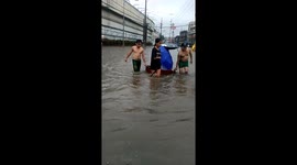 Man walks along flooded street to reach his home and films damages in Valenzuela, Philippines