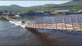 Bridge inches above floodwater collapses as truck drives over it in Russia
