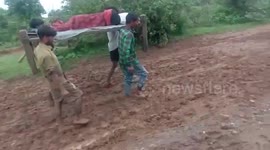 Villagers carry pregnant woman through mud puddle to reach destination in central India