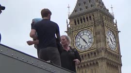 Protester climbs on roof of Russell Brand stage