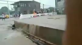 Water overflows onto bridge during strong monsoon in the Philippines