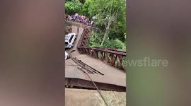 Rescue officers use excavator to tow fallen vehicles after old bridge collapse in the Philippines