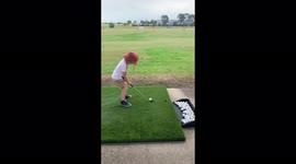 3 year old boy playing golf at the driving range like a pro