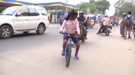 Girl in South India rides a bicycle blind folded in heavily congested roads.