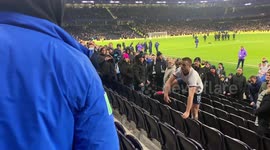 Tottenham midfielder Eric Dier climbs over seats to hit a disrespectful fan