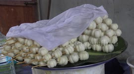 Talented motorcycle rider carries tray of fruit on his head