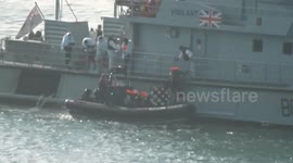 HMS Vigilant hands rescued migrants to a smaller boat in Dover harbour, UK