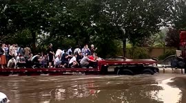 Workers ferried through flooded roads by truck in northern China