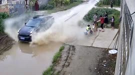 Water splashed to residents on roadside after car speeds through the road in China
