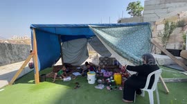Palestinian family sit inside a tent near their house's rubble which was demolished by decision of Israeli forces