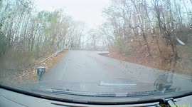 Motorcycle rider survives near-miss accident after slipping on curve on a road