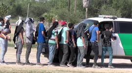 Dozens of migrants cross the border into the United States