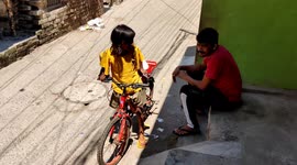 A funny Small girl tryed to learn Bycicle in street