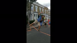 Streetparty tightrope walker. Man walks on a low tightrope during a streetparty in London.