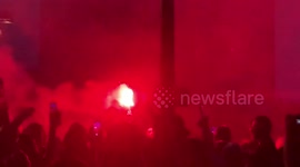 Protesters in red from torches near the parliament house