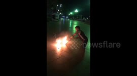 A man without legs performs on the streets of Yalta with a fire show