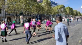Funny guys disguise in women play football (rugby) on the Champs-Elysees.Christo's wrapped Arc-de-Triomphe is visible.It is the Paris day without car,that explain why so many people can walk freely on the street.18sept2021.