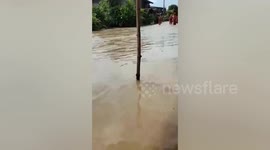 Monk rides basin to cross floods after tropical storm in Thailand