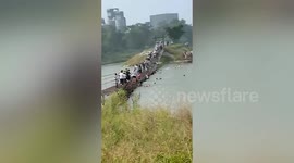 Tourists plunge into river as suspension bridge breaks in central China