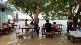 People carry on eating at flooded barbecue restaurant as typhoon Dianmu batters Thailand